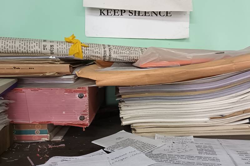 Keep silence sign above pile of books